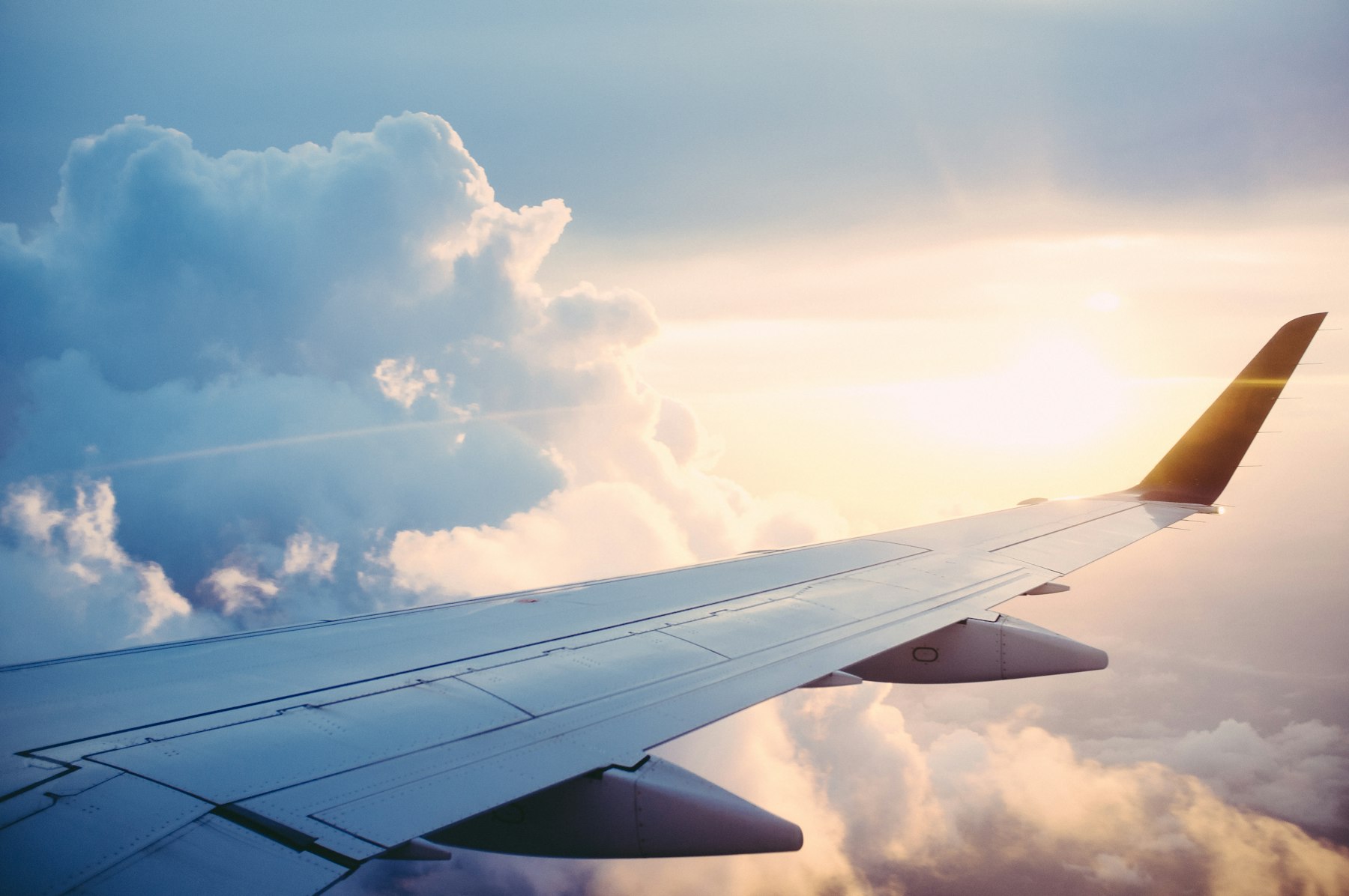 Airplane wing over sunset